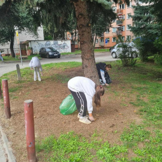 Dzieci zbierają śmieci na osiedlu mieszkaniowym. 