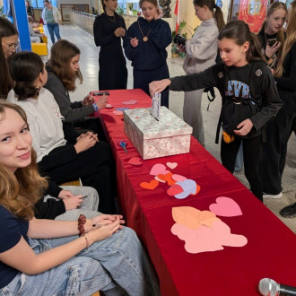 Zadowoleni uczniowie przy skrzynce walentynkowej