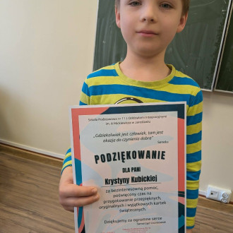 Przewodniczący szkoły składa podziękowanie uczniowi klasy 3a za wykonanie kartek świątecznych