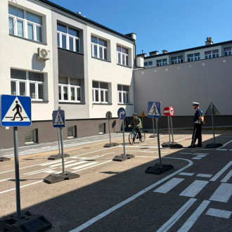 dziecko jedzie na rowerze pod nadzorem policjanta