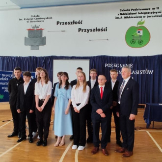 Uśmiechnięci uczniowie klasy ósmej A wraz z wychowawcą i nauczycielem wspomagającym