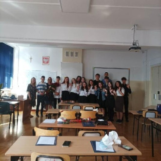 Uśmiechnięci uczniowie klasy ósmej B wraz z wychowawcą i nauczycielem wspomagającym