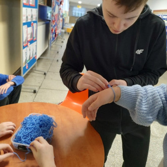 Uczeń podczas wiązania niebieskiego sznurka